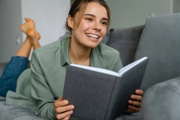 Glad Vacker Kvinna Läser Bok När Ligger Soffan Hemma — Stockfoto