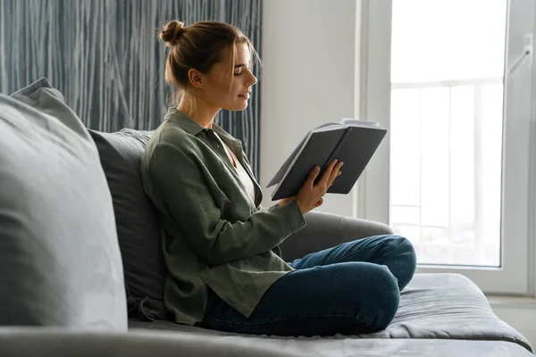 Felice Attraente Giovane Donna Lettura Libro Mentre Seduto Divano Casa — Foto Stock