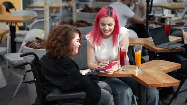 Eine Glückliche Behinderte Frau Blickt Auf Ihr Smartphone Während Sie — Stockvideo