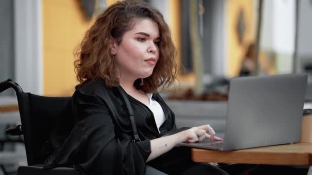 Положительная Женщина Инвалид Использует Свой Ноутбук Сидя Улице Кафе Снаружи — стоковое видео