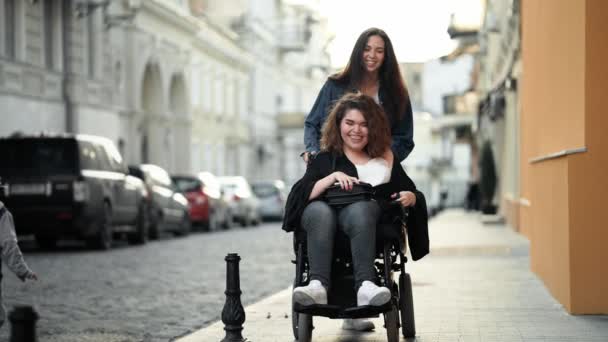Μια Χαμογελαστή Ανάπηρη Γυναίκα Κάθεται Στην Αναπηρική Καρέκλα Ενώ Φίλη — Αρχείο Βίντεο