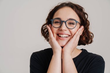 Portrait of a lovely young attractive smiling woman in casual wear posing isolated over white background