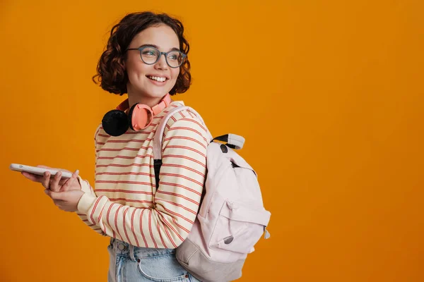 Cheerful Young Girl Backpack Using Mobile Phone While Standing Isolated — Stockfoto