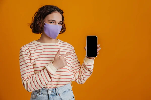 Young Confident Woman Facial Medical Mask Showing Blank Screen Mobile — Fotografia de Stock