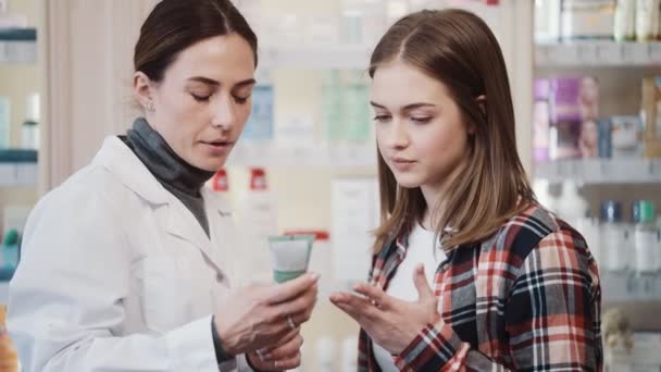Pewny Siebie Farmaceuta Wyjaśnia Klientowi Jak Używać Kremu Medycznego Aptece — Wideo stockowe