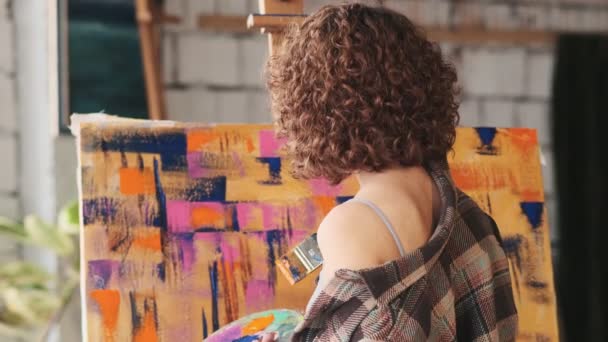 Back View Young Curly Woman Artist Standing Next Easel Painting — Stock Video