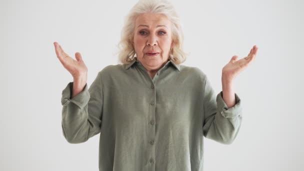 Zmatená Starší Žena Pokrčí Rameny Stojí Izolovaně Přes Bílou Zeď — Stock video