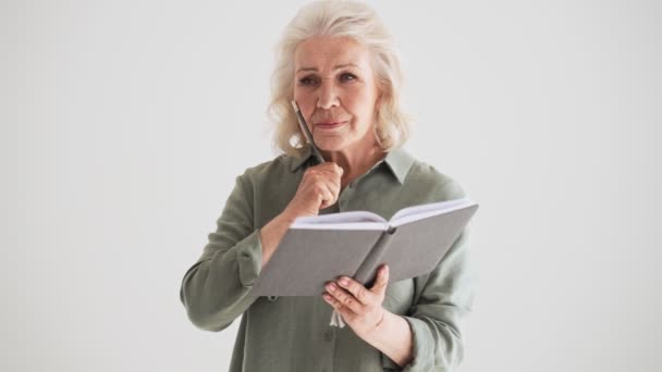 Une Aînée Réfléchie Prend Des Notes Isolées Dessus Mur Blanc — Video