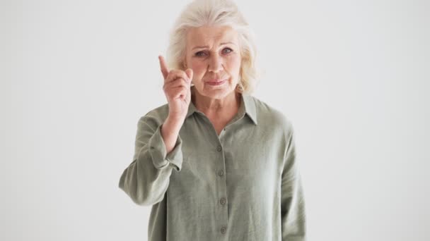 Μια Σοβαρή Ηλικιωμένη Γυναίκα Κουνάει Δάχτυλό Της Και Στέκεται Απομονωμένη — Αρχείο Βίντεο