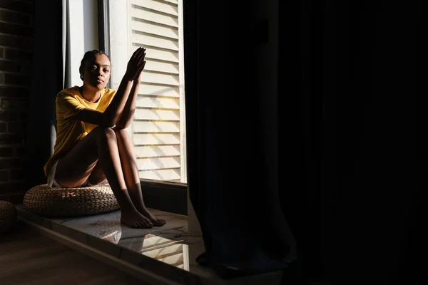 Serious African American Girl Listening Music Earphones While Sitting Window — Stockfoto