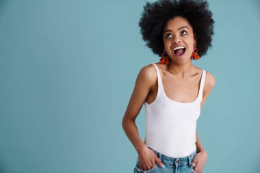 Komik Afrikalı Amerikalı kız gülümsüyor ve mavi arka planda tek başına yukarıya bakıyor.