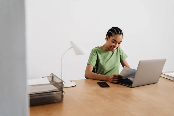 Negro Sonriente Mujer Trabajando Con Ordenador Portátil Papeles Mientras Está — Foto de Stock