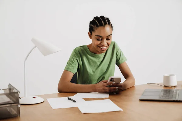 Svart Leende Kvinna Som Använder Mobiltelefon När Arbetar Med Bärbar — Stockfoto