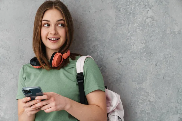 Ευτυχισμένος Ωραίο Κορίτσι Φοιτητής Ακουστικά Χαμογελώντας Και Χρησιμοποιώντας Κινητό Τηλέφωνο — Φωτογραφία Αρχείου