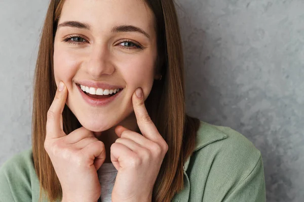 Menina Bonita Agradável Feliz Sorrindo Apontando Dedos Suas Bochechas Isoladas — Fotografia de Stock