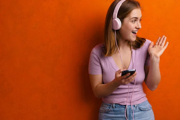 Ung Glad Kvinna Lyssnar Musik Med Hörlurar Och Mobiltelefon Isolerad — Stockfoto