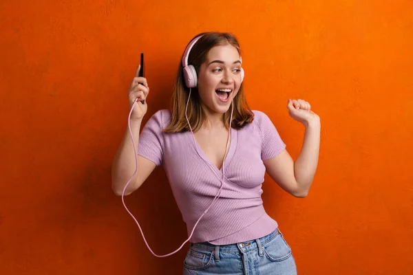 Glada Kvinna Dansar Medan Lyssnar Musik Med Hörlurar Och Mobiltelefon — Stockfoto