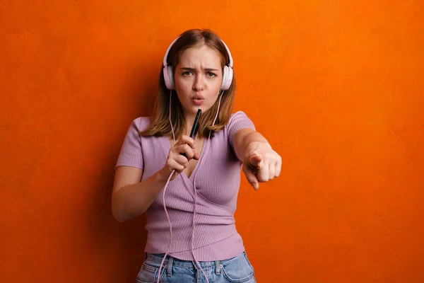 Ung Kvinna Som Använder Hörlurar Och Mobiltelefon Samtidigt Peka Finger — Stockfoto