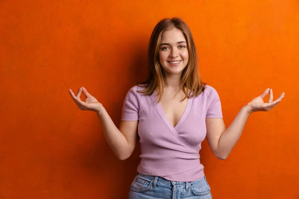 Young Ginger Happy Woman Smiling While Meditating Isolated Orange Wall — 스톡 사진