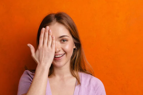 Joven Pelirroja Alegre Mujer Sonriendo Mientras Cubre Ojo Aislado Sobre —  Fotos de Stock