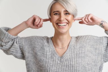Beyaz arka planda izole edilmiş kameraya gülerken kulaklarını tıkayan mutlu gümüş kız.
