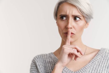 Mutlu olmayan güzel gümüş kız beyaz arka planda izole edilmiş sessizlik hareketi gösteriyor.