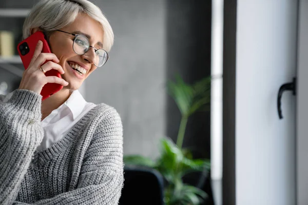 Witharige Lachende Vrouw Gesprek Mobiele Telefoon Terwijl Kantoor Staat — Stockfoto