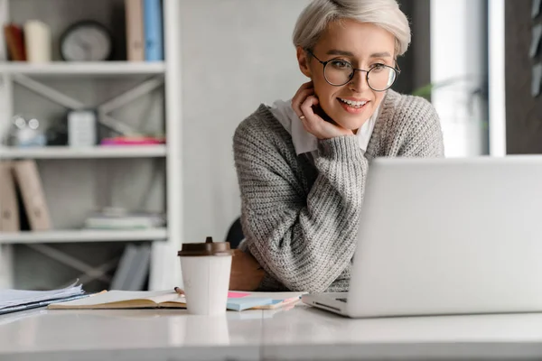 Vithårig Ung Kvinna Ler När Arbetar Med Laptop Kontoret — Stockfoto