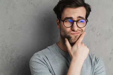 Gri arkaplandan izole edilmiş, günlük kıyafetli yakışıklı bir genç.