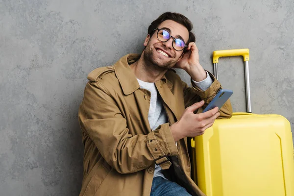 Glad Stilig Kille Som Använder Mobiltelefon Medan Sitter Med Resväska — Stockfoto