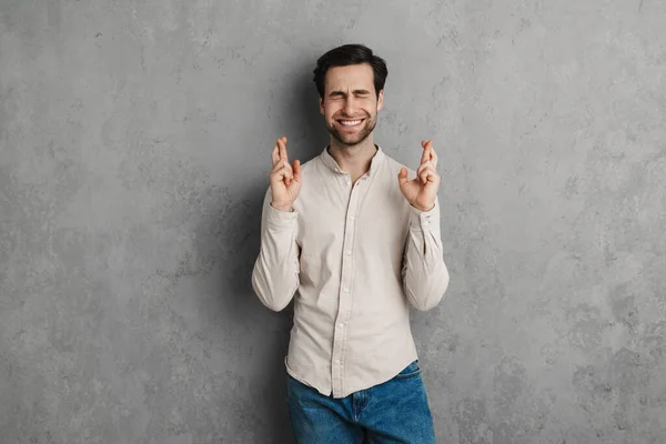 Junger Glücklicher Mann Macht Einen Wunsch Isoliert Auf Grauem Hintergrund — Stockfoto