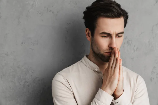 Concentrated Handsome Young Man Praying Closed Eyes Isolated Gray Background — ストック写真