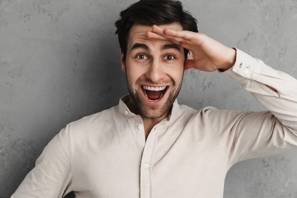 Cheerful Young Handsome Man Looking Far Away Isolated Overgray Background - Stock-foto