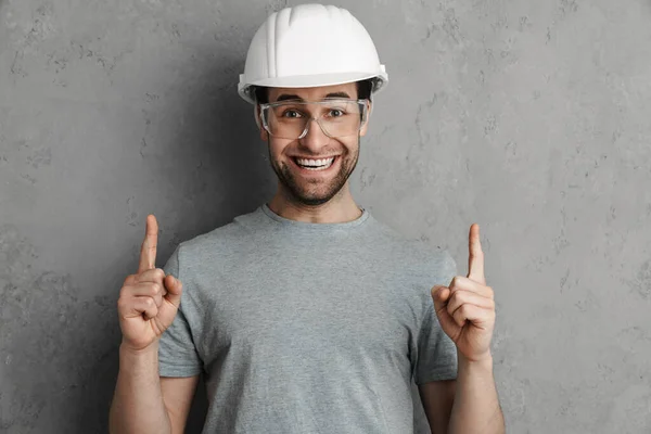 Vreugdevolle Bouwer Man Helm Bril Glimlachend Wijzend Vinger Naar Boven — Stockfoto