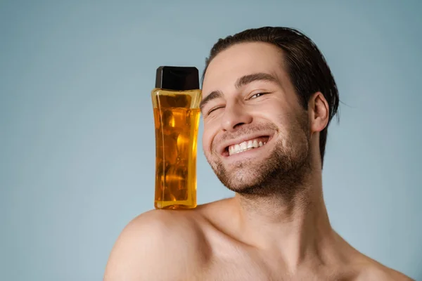 Primer Plano Joven Desnudo Guapo Sonriente Que Presenta Una Botella —  Fotos de Stock