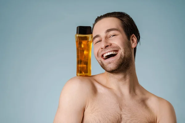 Närbild Leende Stilig Ung Naken Man Presenterar Schampo Flaska Isolerad — Stockfoto