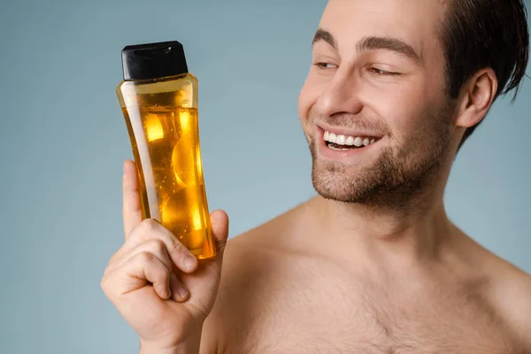 Close Smiling Handsome Young Nude Man Presenting Shampoo Bottle Isolated — Stock Photo, Image