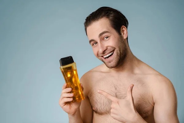 Close Homem Bonito Sorrindo Jovem Apresentando Garrafa Xampu Isolado Sobre — Fotografia de Stock