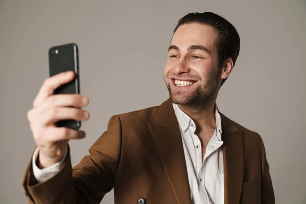 Unshaven Brunette Man Smiling Taking Selfie Cellphone Isolated Grey Background — Stock Photo, Image