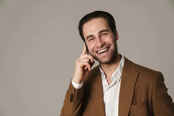 Нездоланний Брюнетка Людина Посміхається Розмовляє Мобільному Телефоні Ізольовано Сірому Фоні — стокове фото