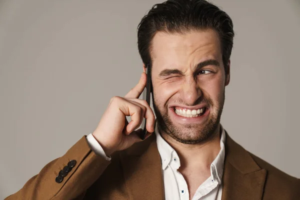 Unshaven Displeased Man Grimacing While Talking Cellphone Isolated Grey Background — Stock Photo, Image