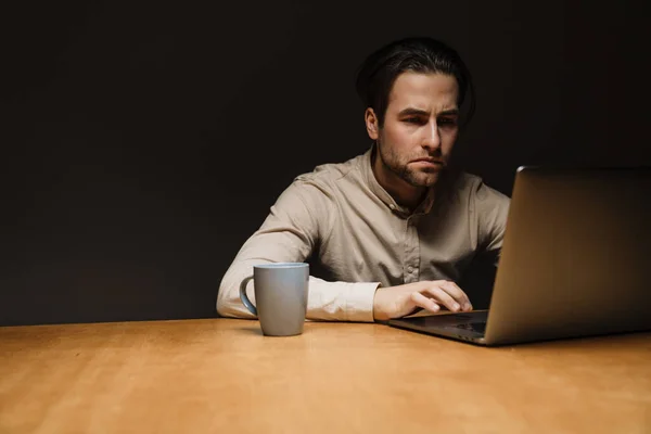 Серьезный Задумчивый Брюнетка Бизнесмен Работающий Ноутбуке Темном Офисе — стоковое фото