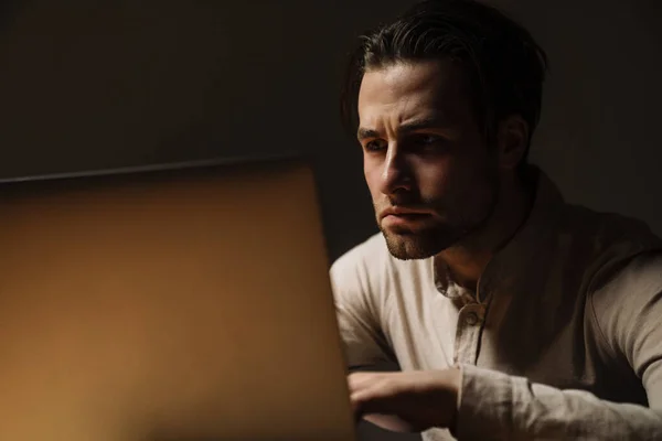 Nachdenklicher Brünetter Geschäftsmann Arbeitet Dunklen Büro Laptop — Stockfoto