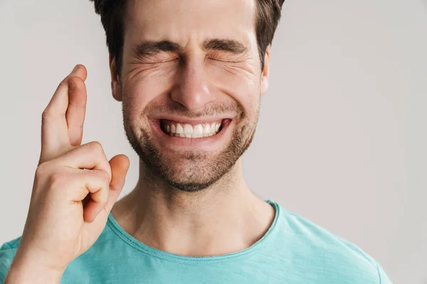 Joven Pidiendo Deseo Aislado Sobre Fondo Gris Sosteniendo Los Dedos — Foto de Stock