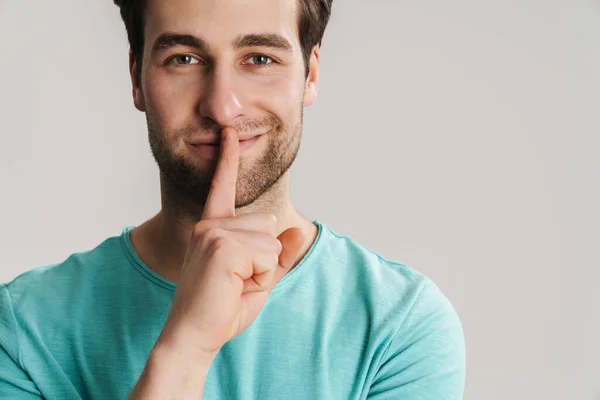 Sorrindo Homem Casual Com Dedo Nos Lábios Mantendo Fundo Cinza — Fotografia de Stock