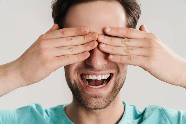 Radostný Pohledný Chlap Usmívá Zakrývá Oči Izolované Přes Bílé Pozadí — Stock fotografie
