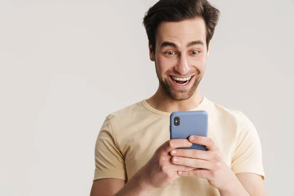 Ενθουσιασμένος Όμορφος Άντρας Χαμογελάει Και Χρησιμοποιεί Κινητό Τηλέφωνο Απομονωμένο Πάνω — Φωτογραφία Αρχείου