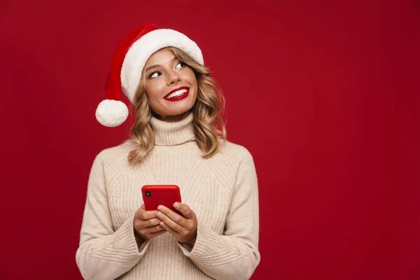 Glad Söt Flicka Santa Hat Hålla Mobiltelefon Över Röd Bakgrund — Stockfoto