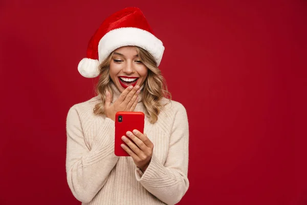 Glad Söt Flicka Santa Hat Hålla Mobiltelefon Över Röd Bakgrund — Stockfoto