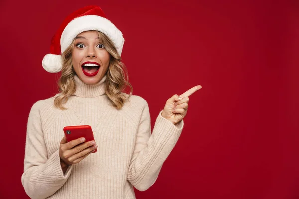 Glad Söt Flicka Santa Hat Hålla Mobiltelefon Över Röd Bakgrund — Stockfoto